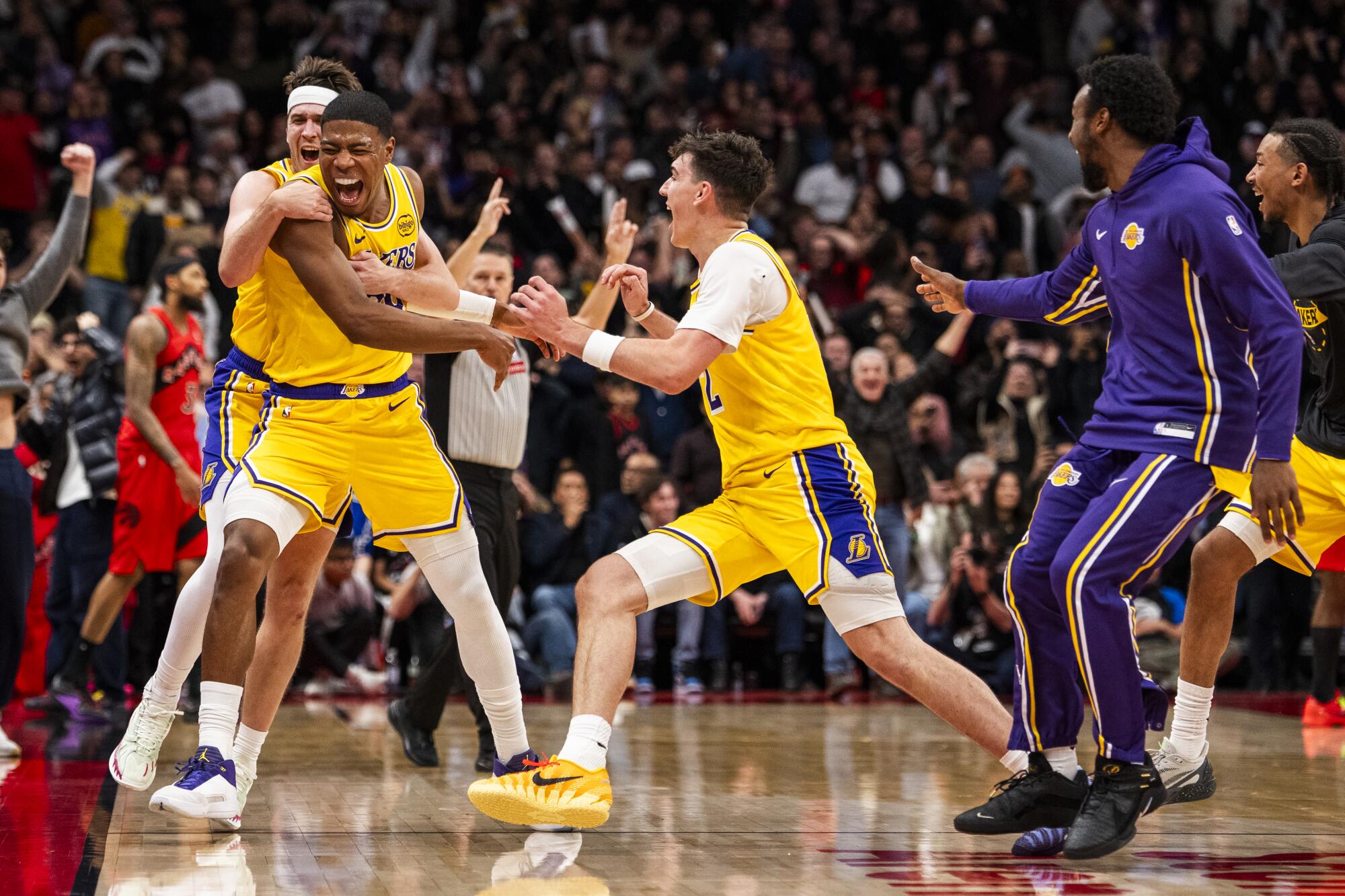 Lakers forveti Rui Hachimura, sol üstte Austin Reaves ve Jake LaRavia ile kutlama yapıyor.