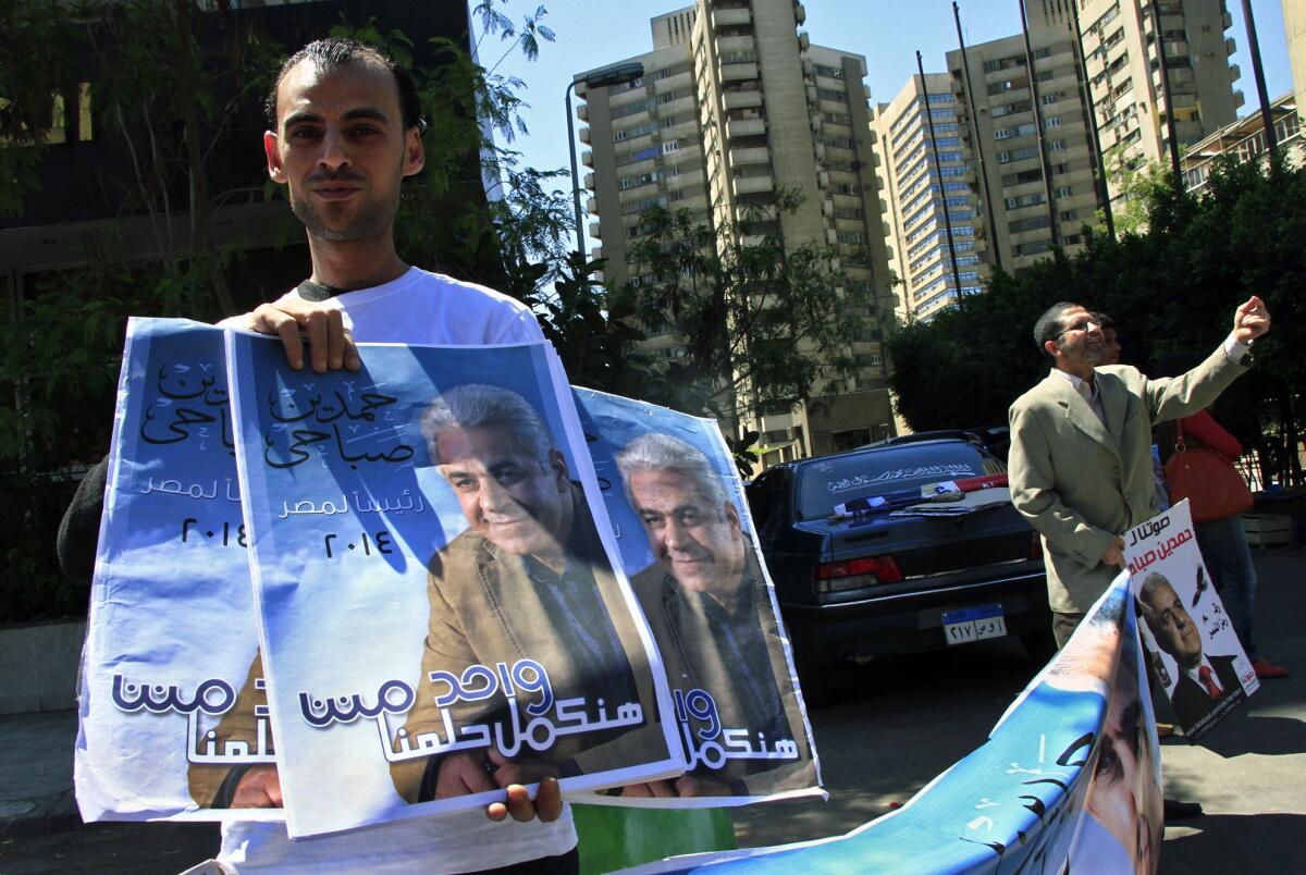Supporters of leftist Egyptian presidential hopeful Hamdeen Sabahi hold posters of him on April 5 outside a Cairo office where citizens can authorize signatures for the nomination process.