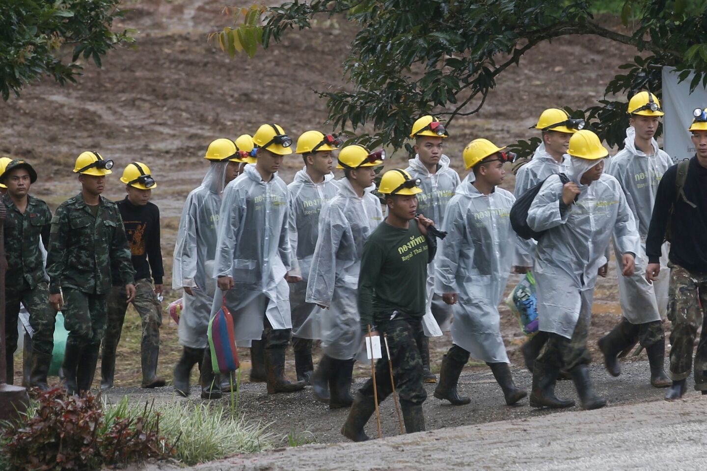 Rescuers walk toward the entrance to a cave complex near Mae Sai, Thailand, before beginning operations July 10 to retrieve the last of those trapped inside the cavern.