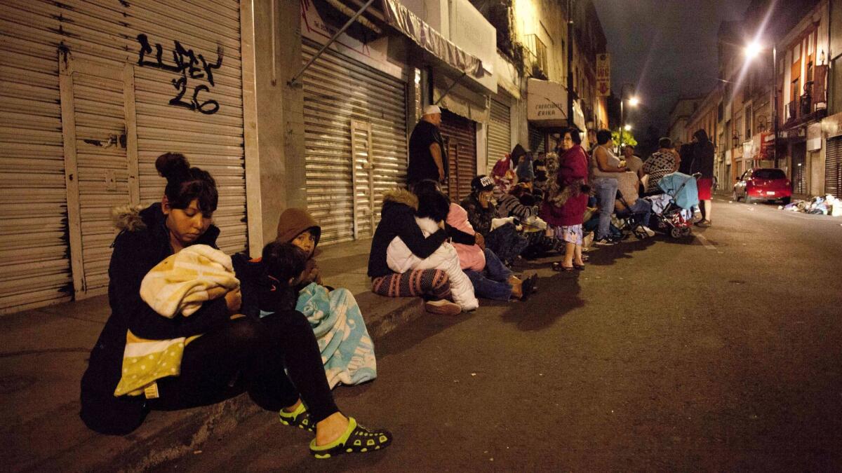 People gather on a street in downtown Mexico City after an earthquake on Thursday.