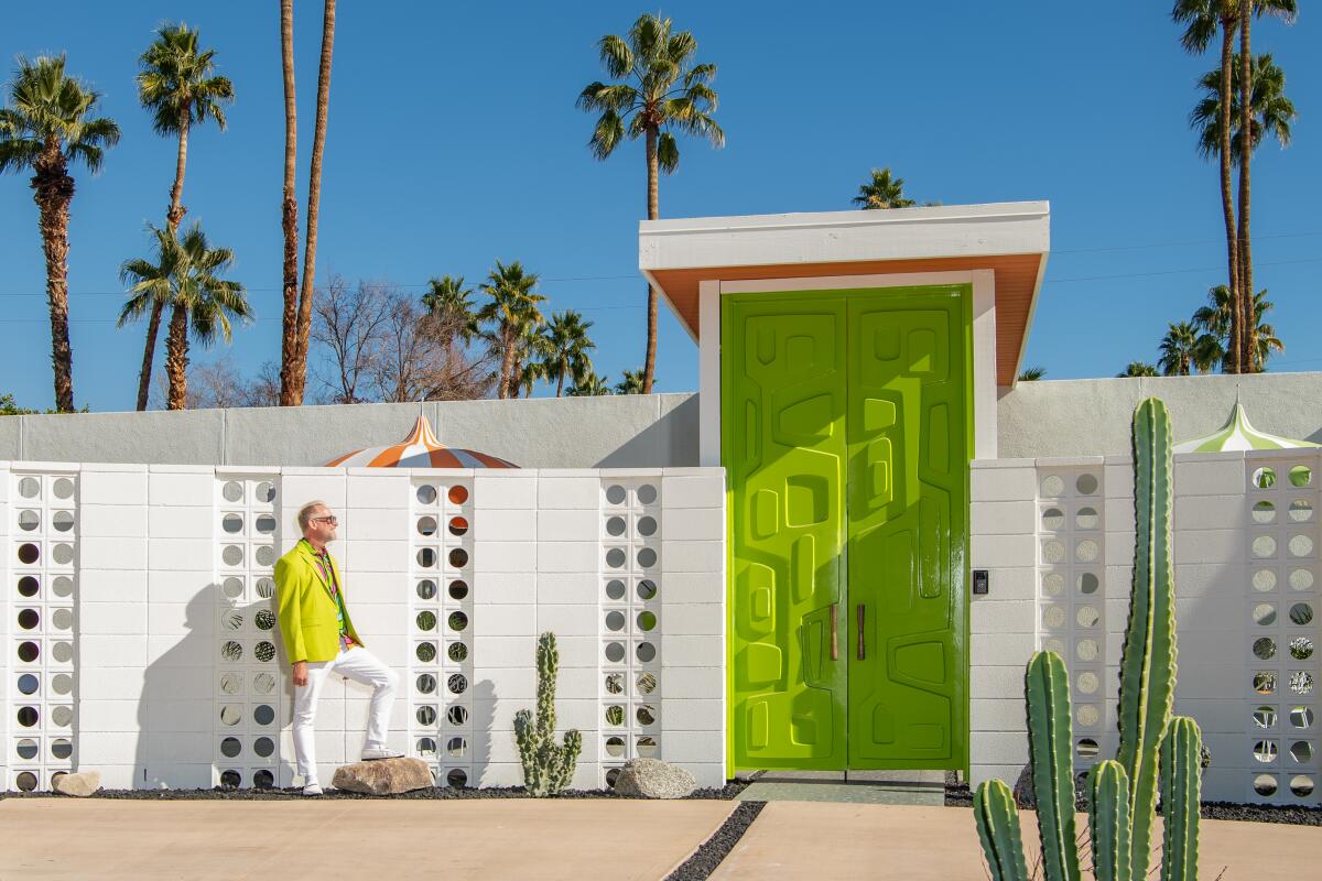 A man in white pants and chartreuse jacket outside the Shag House in Palm Springs.