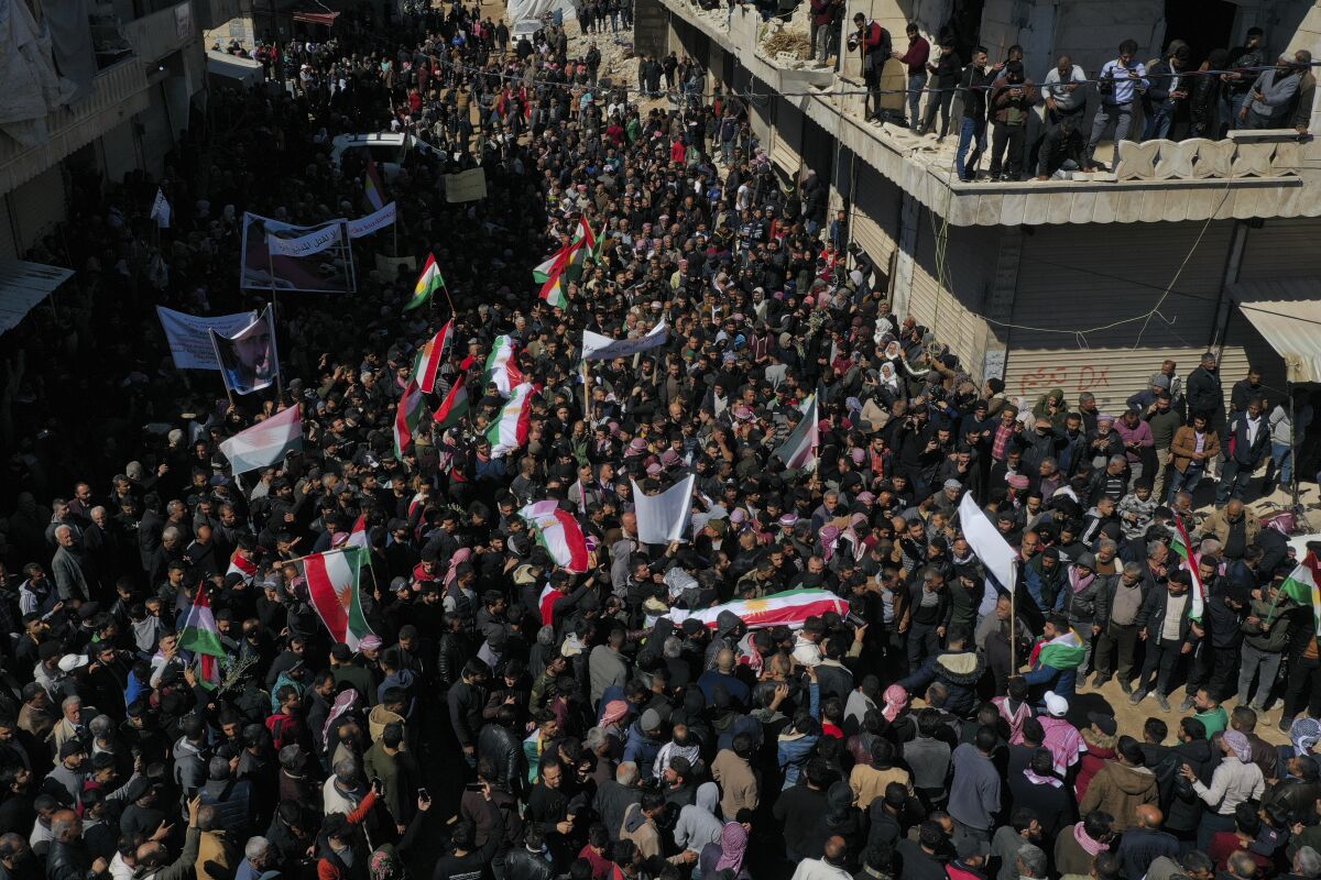 People attend funeral of four four Kurds in the town of Jinderis, Syria, Tuesday, March 21, 2023. The assailants who shot the Kurdish men as they were lighting a fire in celebration of the Nowruz holiday Monday allegedly belonged to Jaish al-Sharqiya, a splinter group of Ahrar Sharqiya. (AP Photo/Ghaith Alsayed)