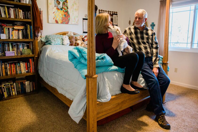 PRESCOTT, AZ-DECEMBER 19, 2019: Marsha and Carl Mueller hold Benji, a yorkiepoo, they planned to give to their daughter Kayla upon her return from Syria, in room at their home in Prescott, Ariz. on Dec. 19, 2019. Kayla Mueller was a humanitarian aid worker who was captured by Islamic State fighters in 2014. (Caitlin O’Hara / For The Times)