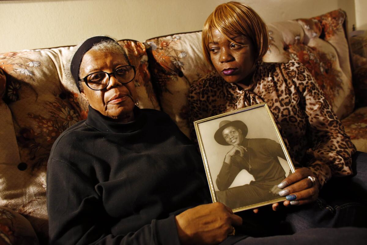 Alma Murdough, left, and her daughter Cheryl Warner hold a photo of Murdough's son, Jerome. On Feb. 15, jail staff discovered a lifeless Murdough in a 101 degree jail cell.