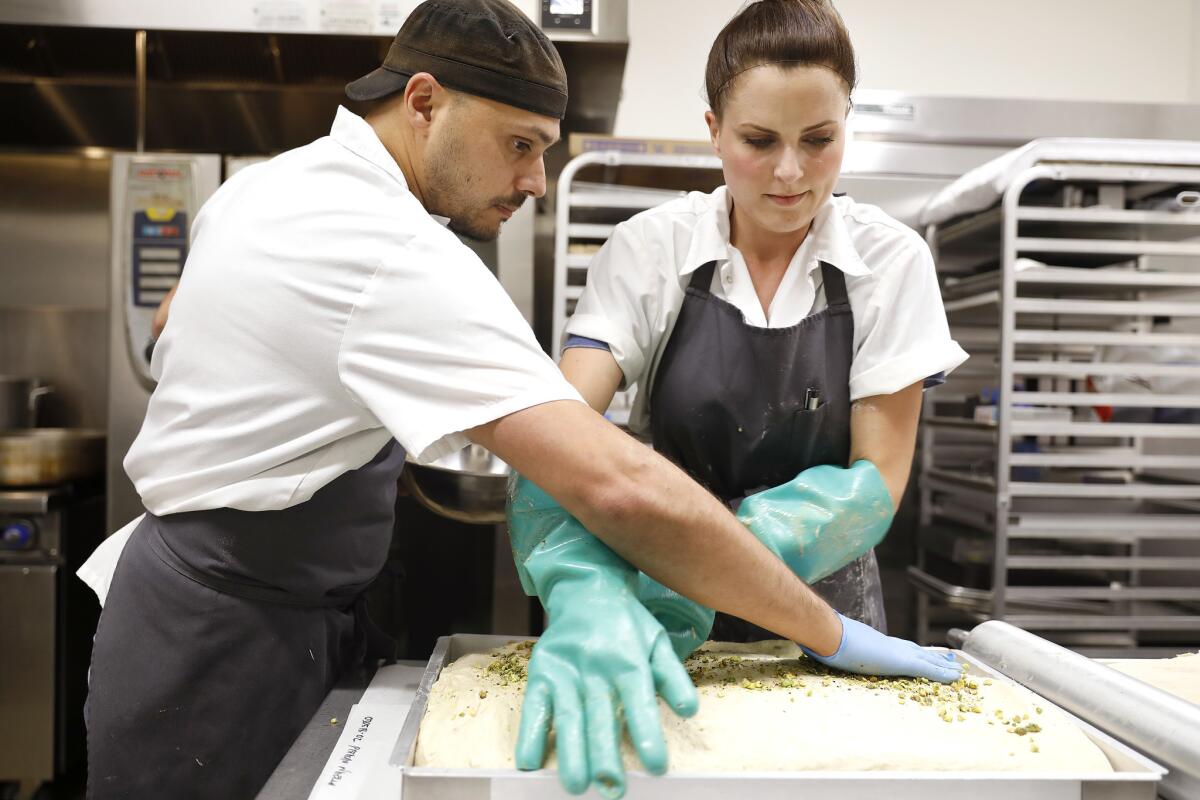 Scott Hebel, left, and Katie Gurvin of Hebel & Co. smooth out halvah and top with pistachios at Crafted Kitchen.