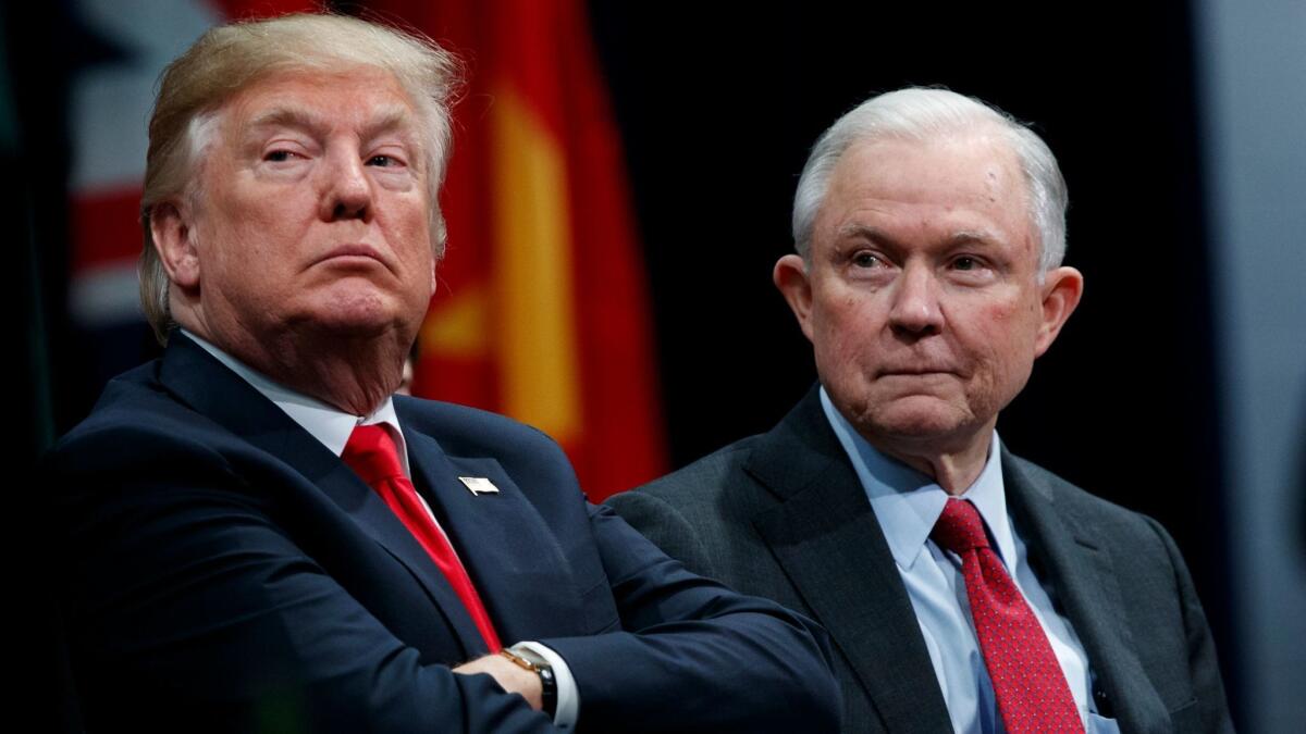President Trump sits and Atty. Gen. Jeff Sessions.