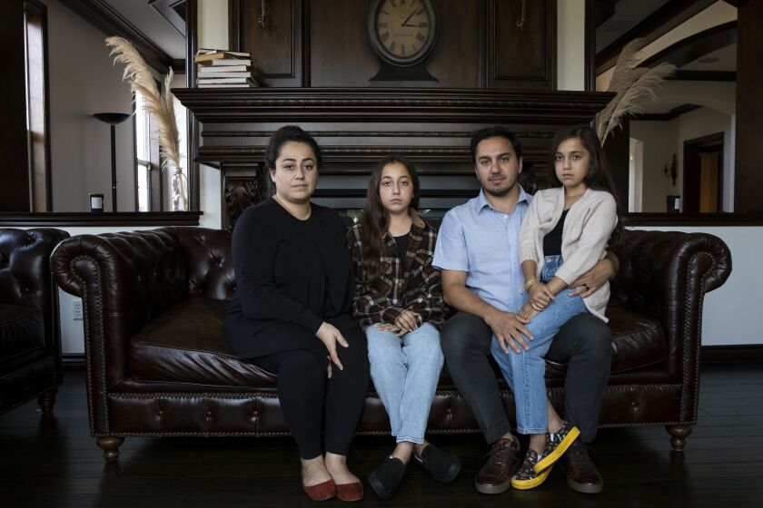 San Marcos, CA - August 17: From left, Nargis Habib, 33, Ferdouse, 13, Rayaan, 10, and Jawid, 33, pose for a portrait on Tuesday, Aug. 17, 2021 in San Marcos, CA. Nargis was visiting family in Herat, Afghanistan but came back three weeks early because the Taliban was approaching after the United States pulled out military troops. Jawid also has family in Afghanistan and said they talk openly with their daughters about the situation. Nargis said she speaks to mother as often as possible but its hard because the Taliban cutoff the internet and electricity. She said her mother said she waits to cry after Nargis' younger sibling are asleep. "It's terrifying being so far away," she said. (Ana Ramirez / The San Diego Union-Tribune)