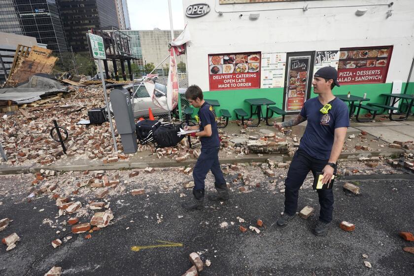 New Orleans Firefighters assess damages as they look through debris after a building collapsed from the effects of Hurricane Ida, Monday, Aug. 30, 2021, in New Orleans, La. (AP Photo/Eric Gay)