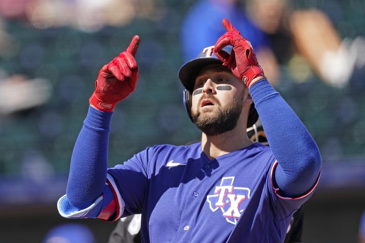 FILE - Texas Rangers' Joey Gallo celebrates as he crosses the plate after hitting a two-run home run during the first inning of a spring training baseball game against the Kansas City Royals, in Surprise, Ariz., in this Sunday, Feb. 28, 2021, file photo. Gallo went into spring training trying to lower his launch angle, straighten up his posture and hit more line drives. The Texas Rangers slugger wasn't worried about trying to hit home runs. (AP Photo/Charlie Riedel, File)
