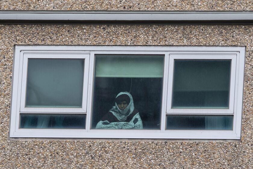 A woman looks out a window from a locked-down public housing tower in Melbourne, Monday, July 6, 2020. As Australia is emerging from pandemic restrictions, the Victoria state capital Melbourne is buckling down with more extreme and divisive measures that are causing anger and igniting arguments over who is to blame as the disease spreads again at an alarming rate. (AP Photo/Andy Brownbill)