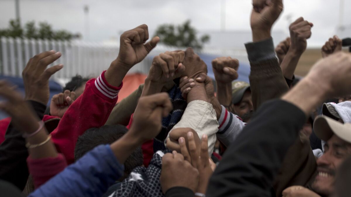 Migrants in Tijuana celebrate after hearing the news that U.S. border inspectors allowed some of the Central American asylum-seekers to enter the country for processing on April 30.