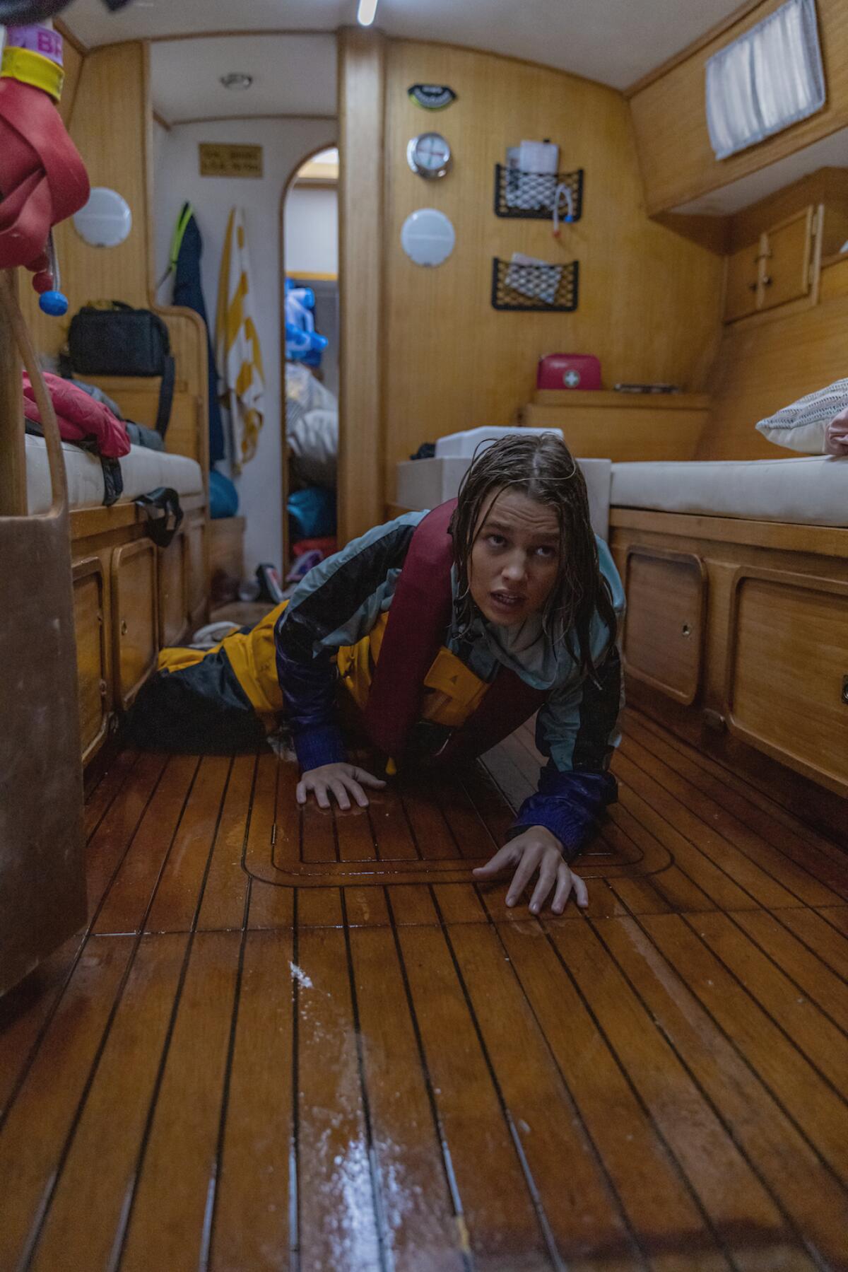 Teagan Croft lies on a floor inside a boat in the movie "True Spirit."