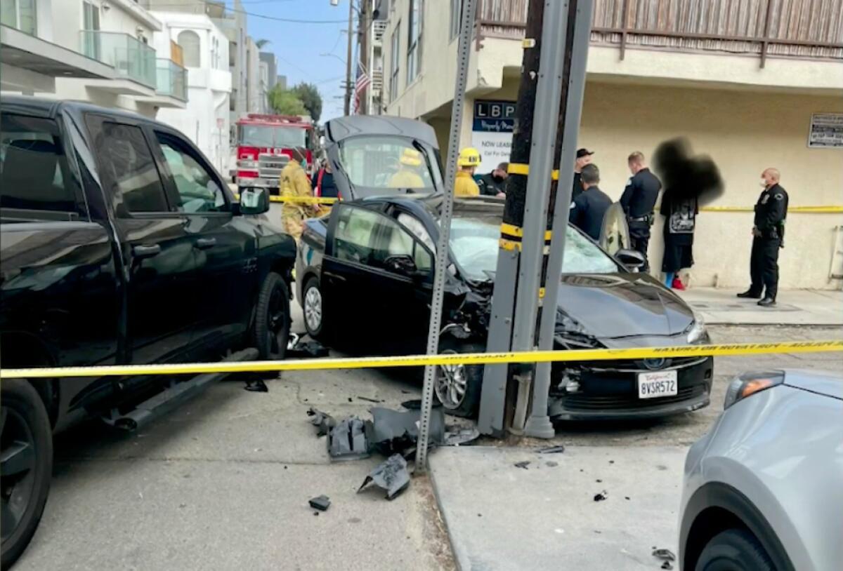 A car crashed into a pole with yellow crime scene tape around it