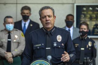 LOS ANGELES, CA - AUGUST 26, 2020: LAPD Chief Michel Moore addresses the media during a press conference held outside of LAPD Headquarters in downtown Los Angeles, announcing significant crime arrests made by the multi-agency SAFELA Task Force, which was formed to investigate crimes that occurred during protests and demonstrations in Los Angeles back in May and June. The LAPD has arrested 14 people as a result. At left is Los Angeles County Sheriff Alex Villanueva, 2nd from left is David Singer, U.S. Marshall for the Central District of California, and at right is Cynthia Renaud, Chief of the Santa Monica Police Dept. (Mel Melcon / Los Angeles Times)