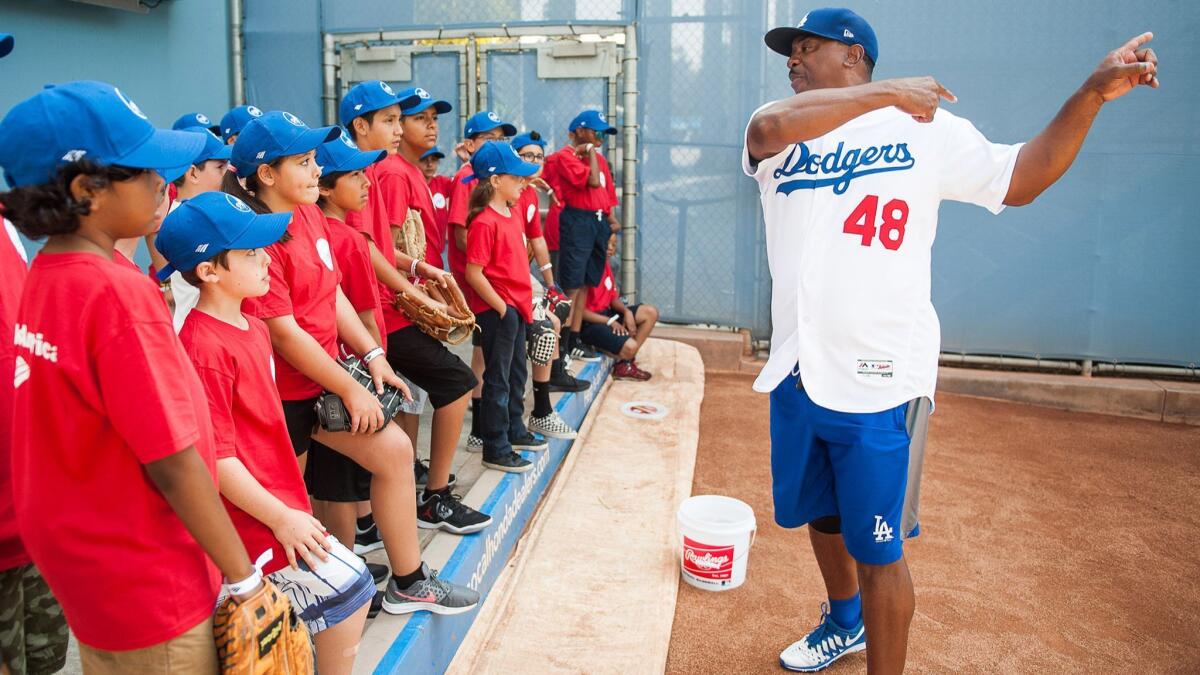 Members of the Boys & Girls Club of Burbank and Greater East Valley listen as former Dodger pitcher Dennis Powell explains how to pitch in the Dodger Stadium bullpen.