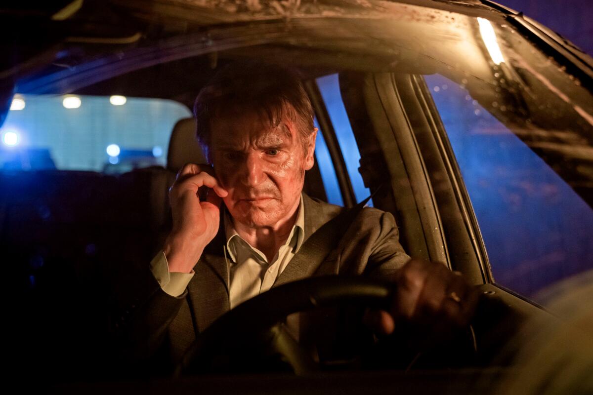 An angry man listens to a cell phone in his car.