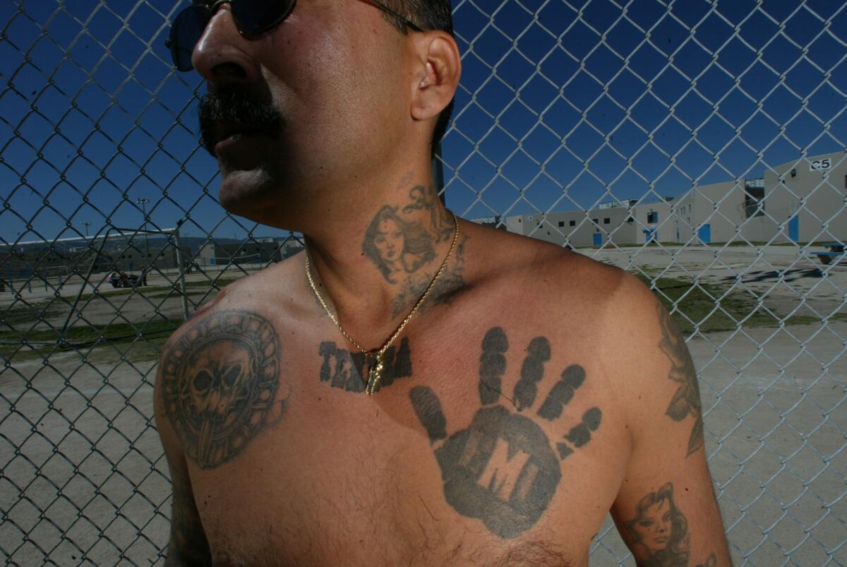 Showing a "Black Hand" tattoo of the Mexican Mafia, Rene Enriquez, former member of the group, talks at the state prison in Lancaster about the development of the underground criminal organization. He is serving life for two murders committed while he was part of the Mexican Mafia.