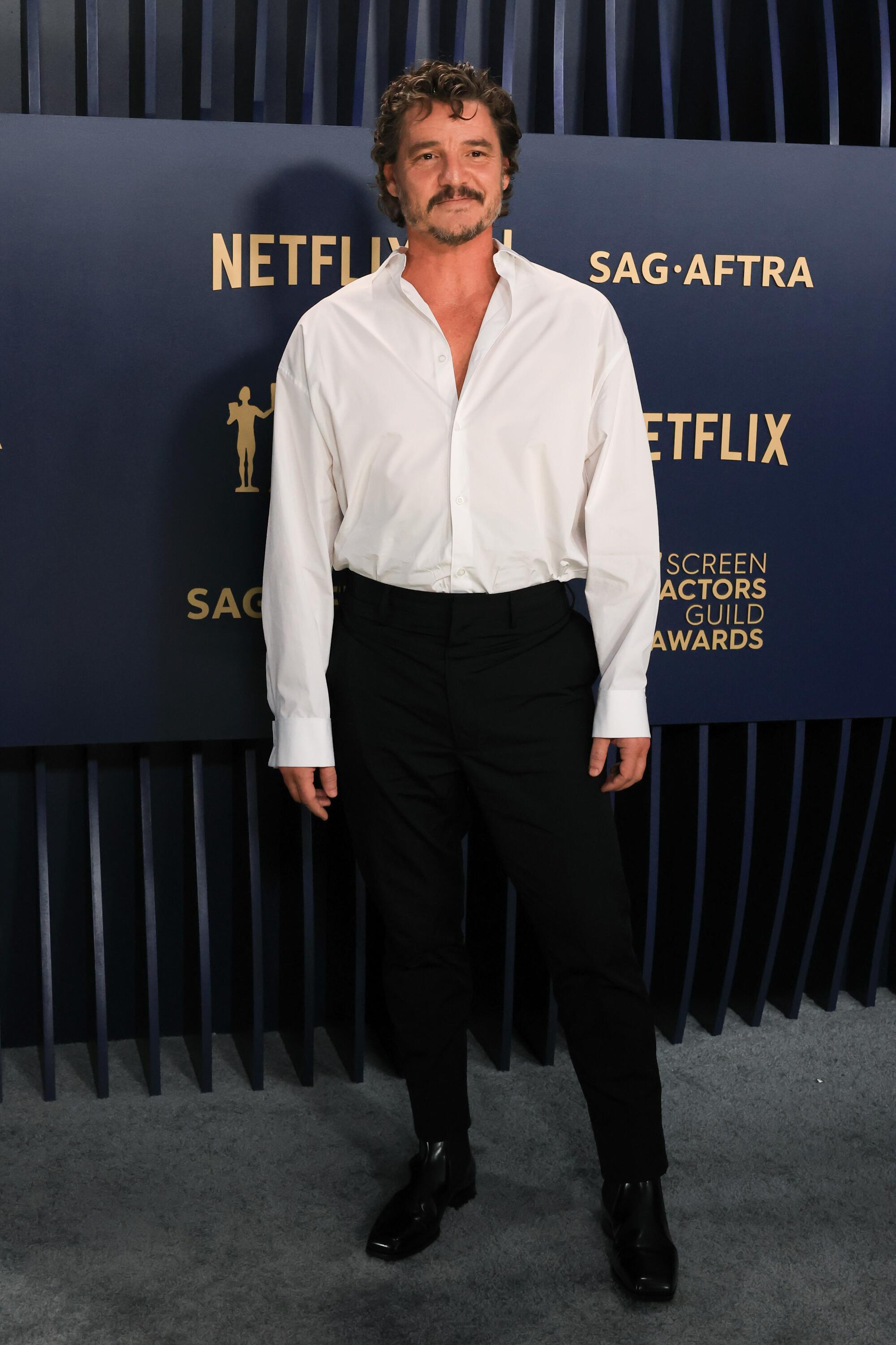 Pedro Pascal wears a white shirt and black pants at the SAG Awards.