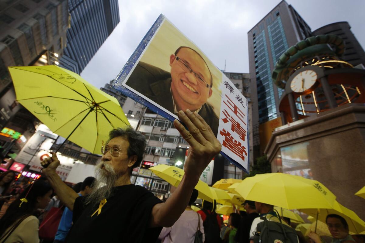 Anti-Beijing protesters, holding yellow umbrellas and a picture of human rights activist Wang Qingying, protest to demand Wang's release in Hong Kong on July 23.
