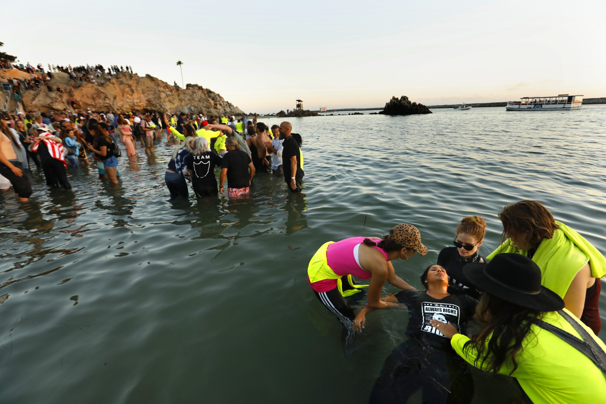 Amber Strayhand, right, is baptized at Corona Del Mar State Beach on July 31 as part of Saturate OC.
