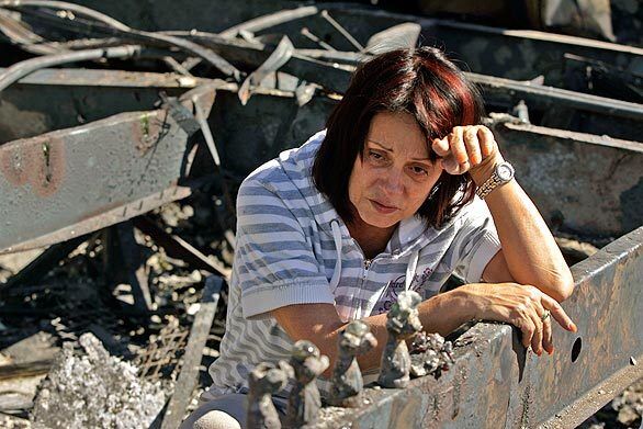 Rita Lythgoe takes a break from sifting through the rubble of her mobile home, which was destroyed by a fast-moving fire that raced through Sky Terrace Mobile Lodge in Lopez Canyon, near Lake View Terrace.