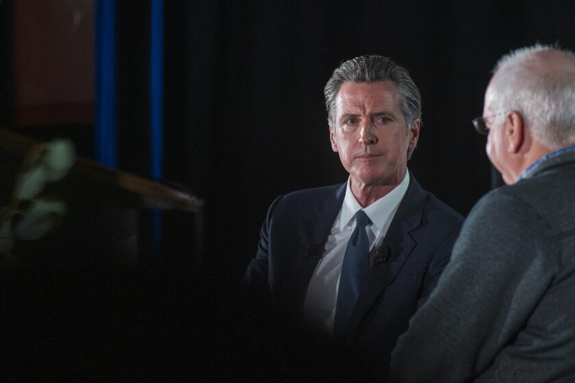 California Gov. Gavin Newsom, left, talks with Lenny Mendonca, leadership council member of California Forward, at the California Economic Summit in Monterey, Calif., Tuesday, Nov. 9, 2021. (AP Photo/Nic Coury)