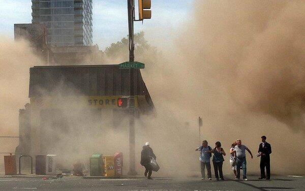 A dust cloud rises as people run from the scene of a building collapse on the edge of downtown Philadelphia on Wednesday.