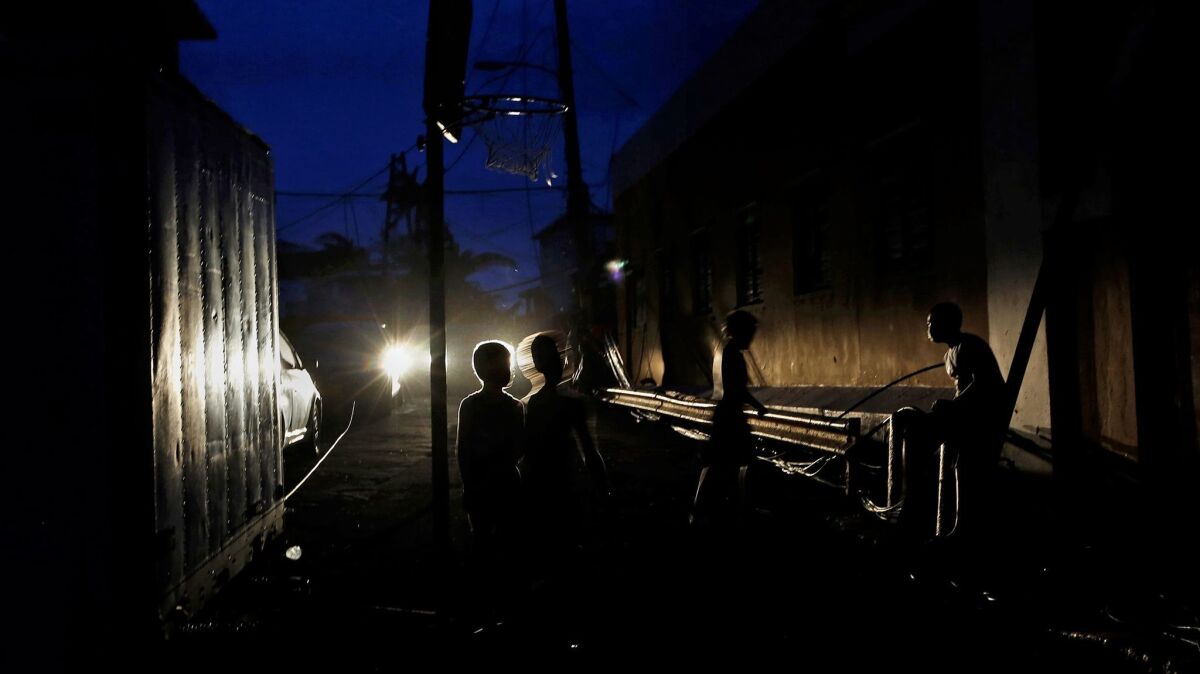 Boys play basketball in near darkness in the La Perla area of San Juan, Puerto Rico, which has no electricity after being battered by Hurricane Maria.