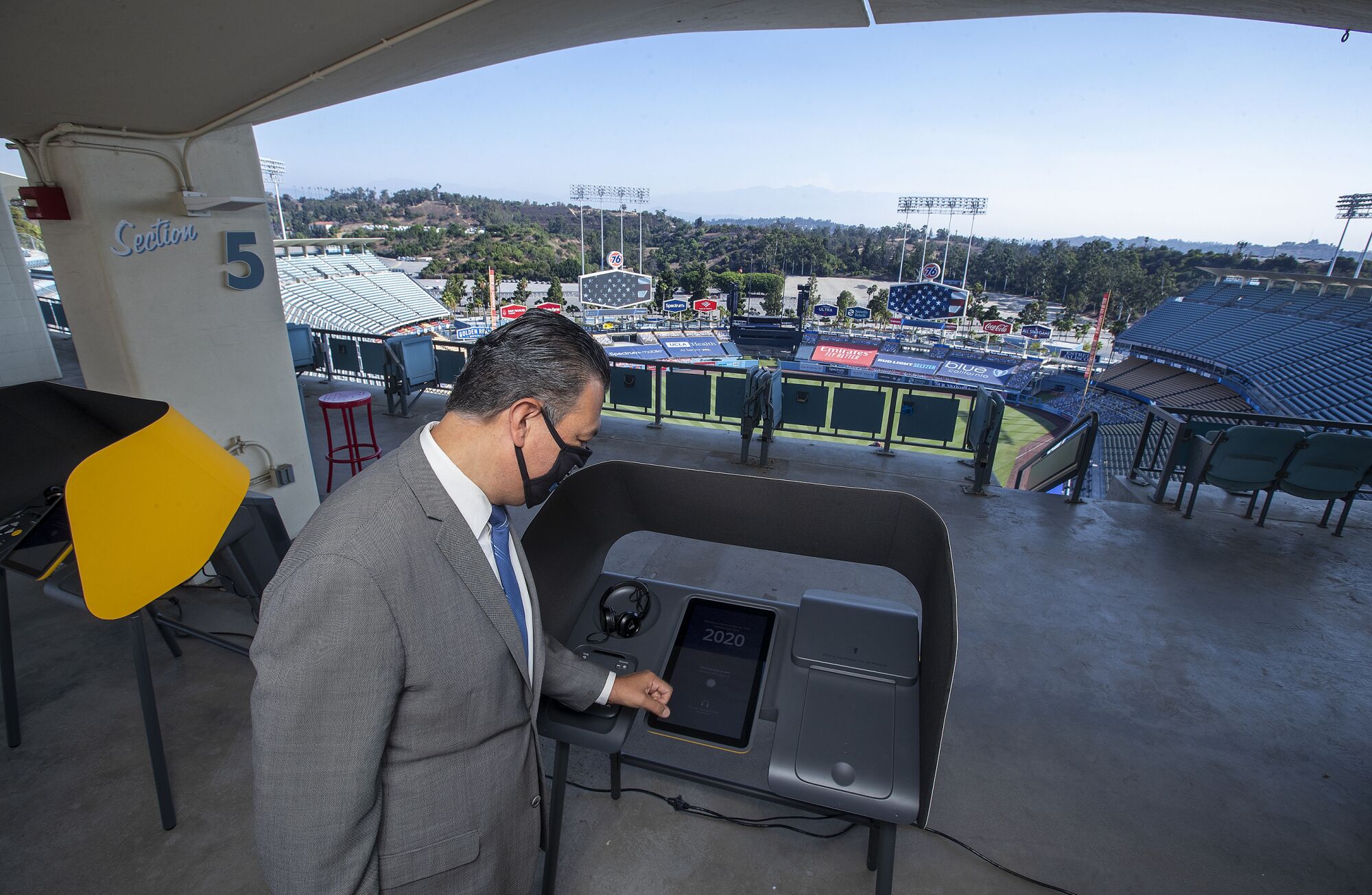 California Secretary of State Alex Padilla checks out a voting booth on display at Dodger Stadium. 