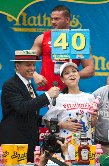 Sonya Thomas (R) smiles as she finishes the 2011 Nathan's Famous Fourth of July International Hot Dog Eating Contest.
