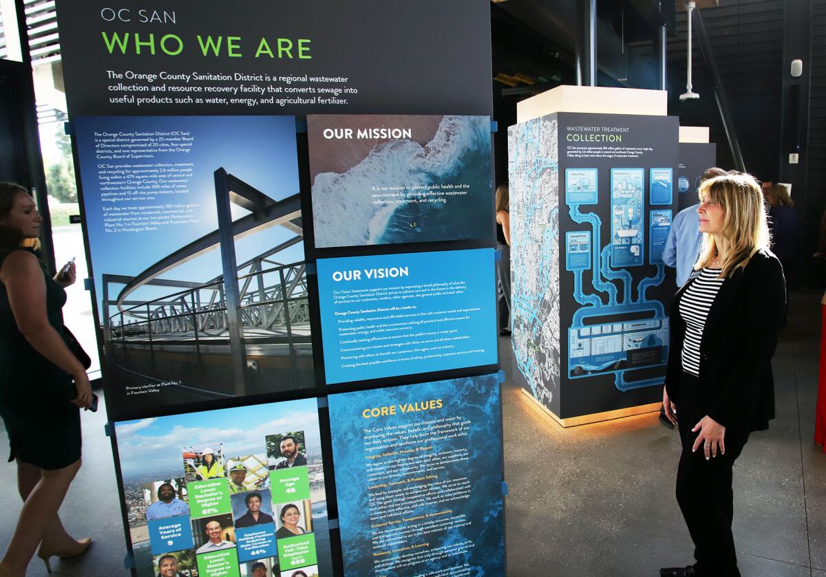 Guests read an educational exhibit at the new headquarters of the O.C. Sanitation District on Wednesday.