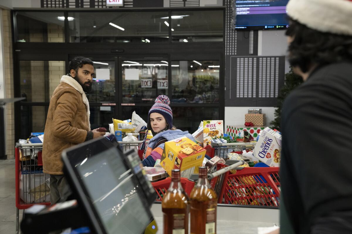 A man and a young girl at a store checkout counter.