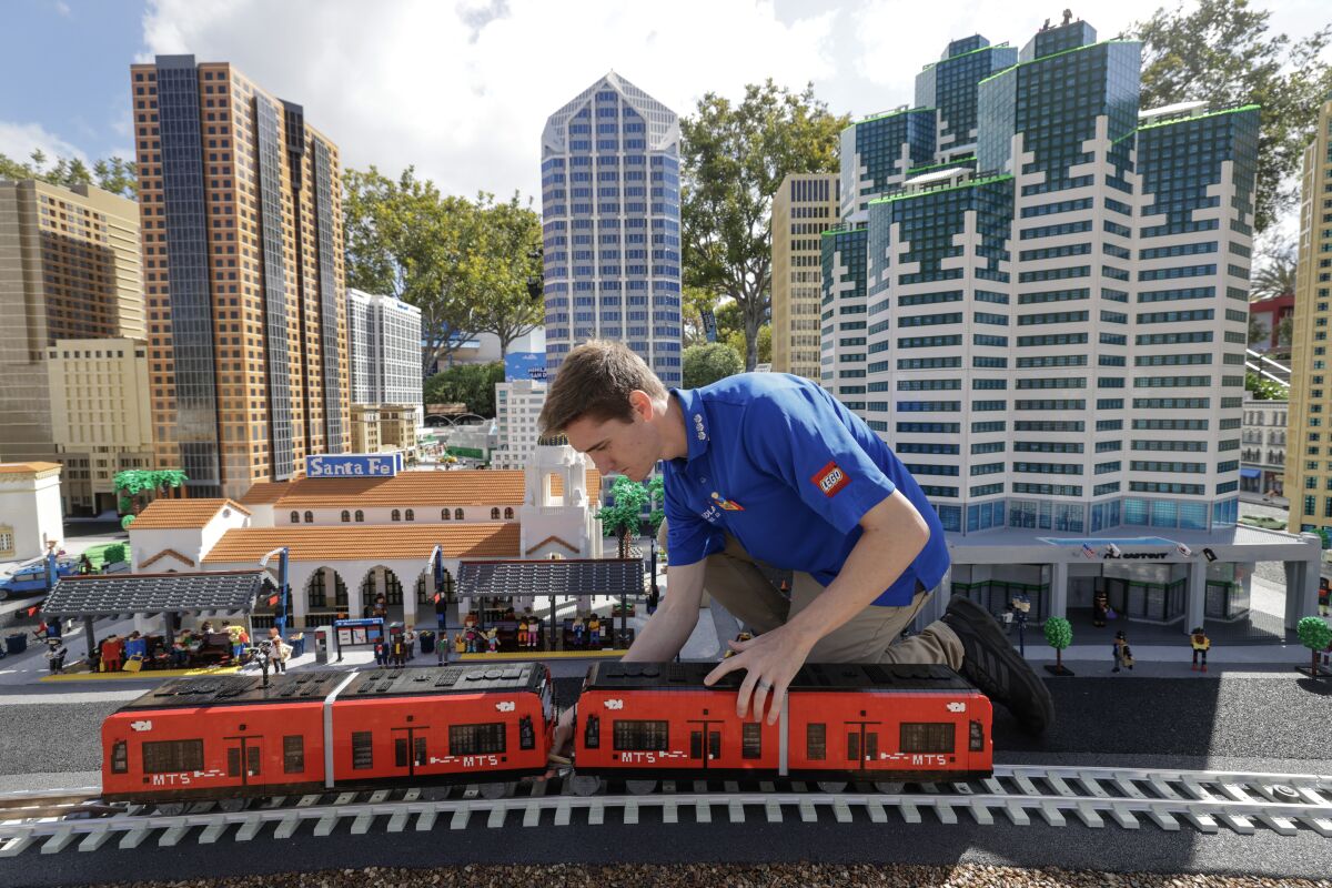 Master Model Builder Carter Cummings, 26, works on a LEGO version of the San Diego Trolley.