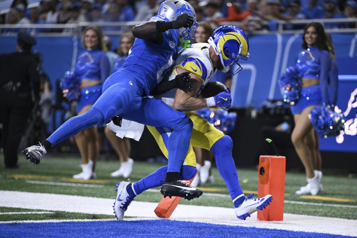 Rams receiver Cooper Kupp (10) scores on a nine-yard reception as Lions cornerback Terrion Arnold (0) pursues.