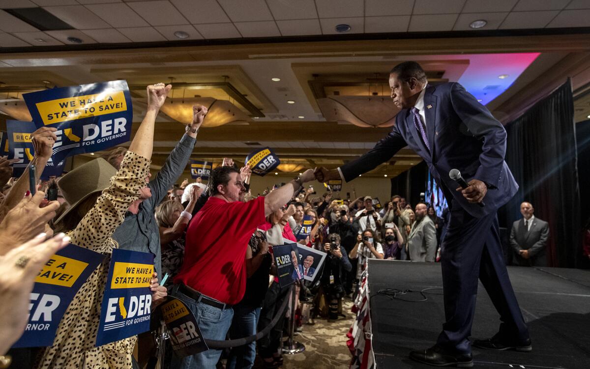 Larry Elder gives a fist bump to a supporter.