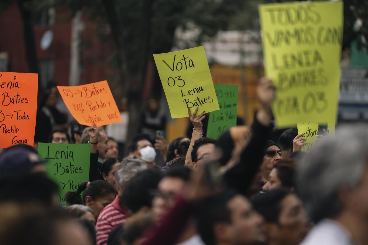 Supporters carry signs to promote voting during a rally