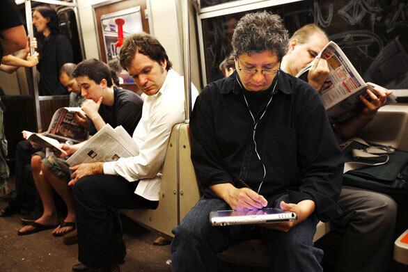 A man looks over Ed Velandria's shoulder as he draws a portrait of a fellow subway rider. Velandria uses a computer tablet and touch pen for his sketches. He tries to capture people who arent paying attention to him, and he has mastered the game of avoiding eye contact with his subjects. Everyone is so different, no matter how much you lump people together, he says. I guess my ultimate goal is to really capture the soul of a person.