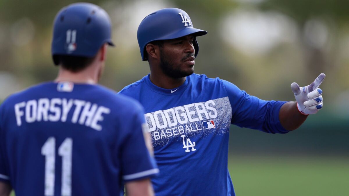 The Dodgers' Yasiel Puig talks with teammate Logan Forsythe during spring training on Feb. 19.
