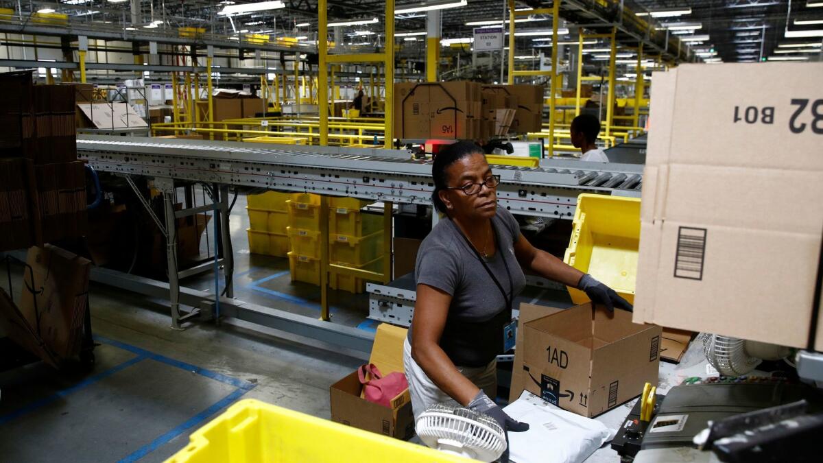 Myrtice Harris packages products for shipment at an Amazon fulfillment center in Baltimore. The nation’s largest online retailer said it sold more than 200,000 toys in the first five hours of Black Friday.