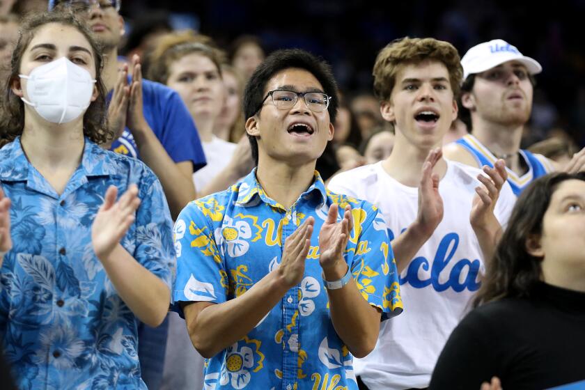 LOS ANGELES, CA - MARCH 11: UCLA gymnastics super fan Josh Lim, 19, center, a third-year double major.
