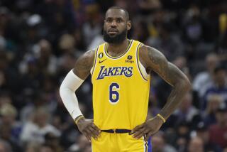 Los Angeles Lakers forward LeBron James stands on court with hands on hips.