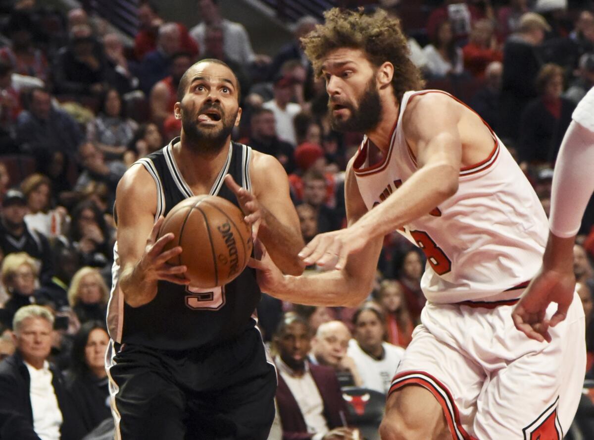 Spurs guard Tony Parker (9) is defended by Bulls center Robin Lopez (8) during the second half on Dec. 8.