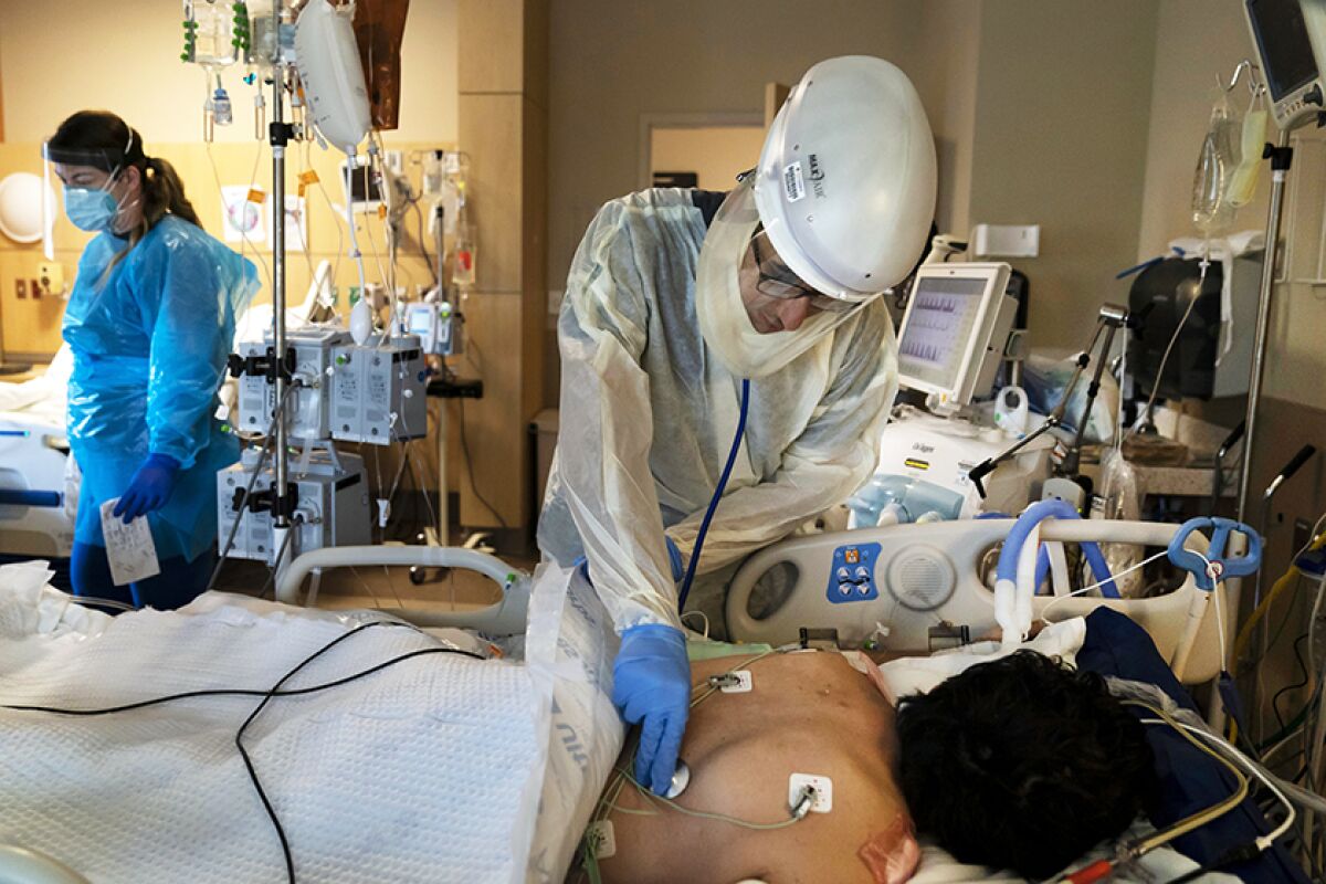 A physician checks on a COVID-19 patient at Providence Holy Cross Medical Center in Los Angeles.