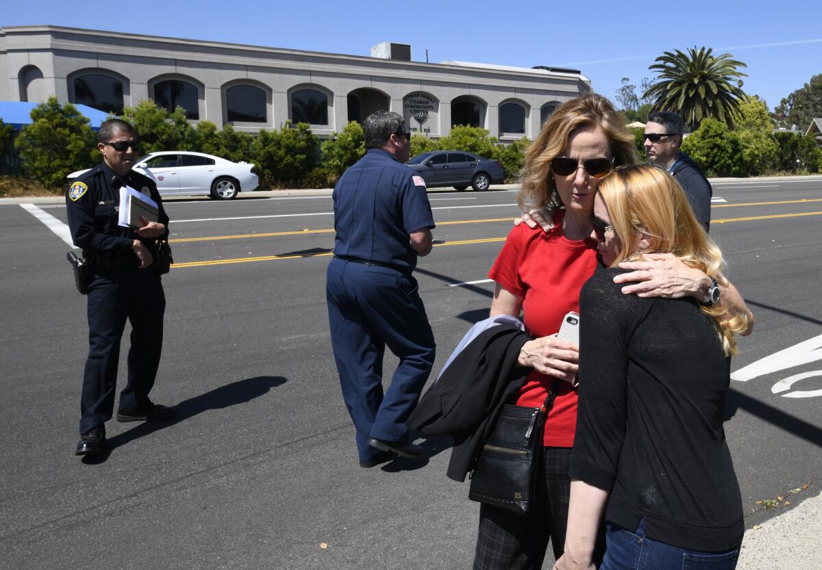 Jessica Parks, right, hugs Tina White outside Chabad of Poway synagogue.