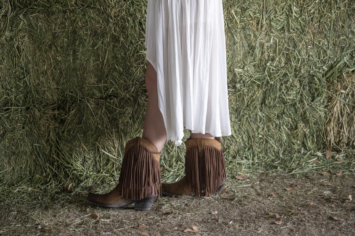 A fan gets a front hay bale view of Lillie Mae performing on the Palomino Stage.