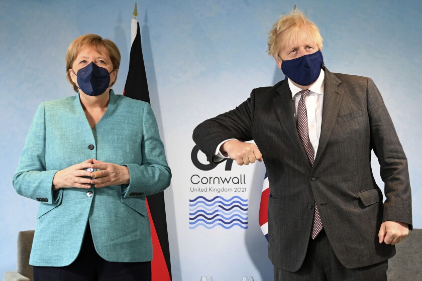 Britain's Prime Minister Boris Johnson, right, greets German Chancellor Angela Merkel ahead of a bilateral meeting during the G7 summit in Cornwall, England, Saturday June 12, 2021. (Stefan Rousseau/Pool via AP)