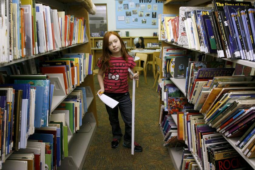Katrina Polikolsky, 8, of La Crescenta takes part in a scavenger hunt at the Montrose Library in January 2014. In a presentation to the City Council Tuesday night, City Manager Scott Ochoa said the elimination of the utility users tax and the potential $17.5-million reduction in the city's General Fund could trigger widespread cuts and layoffs in the city's Library Arts and Culture Department.