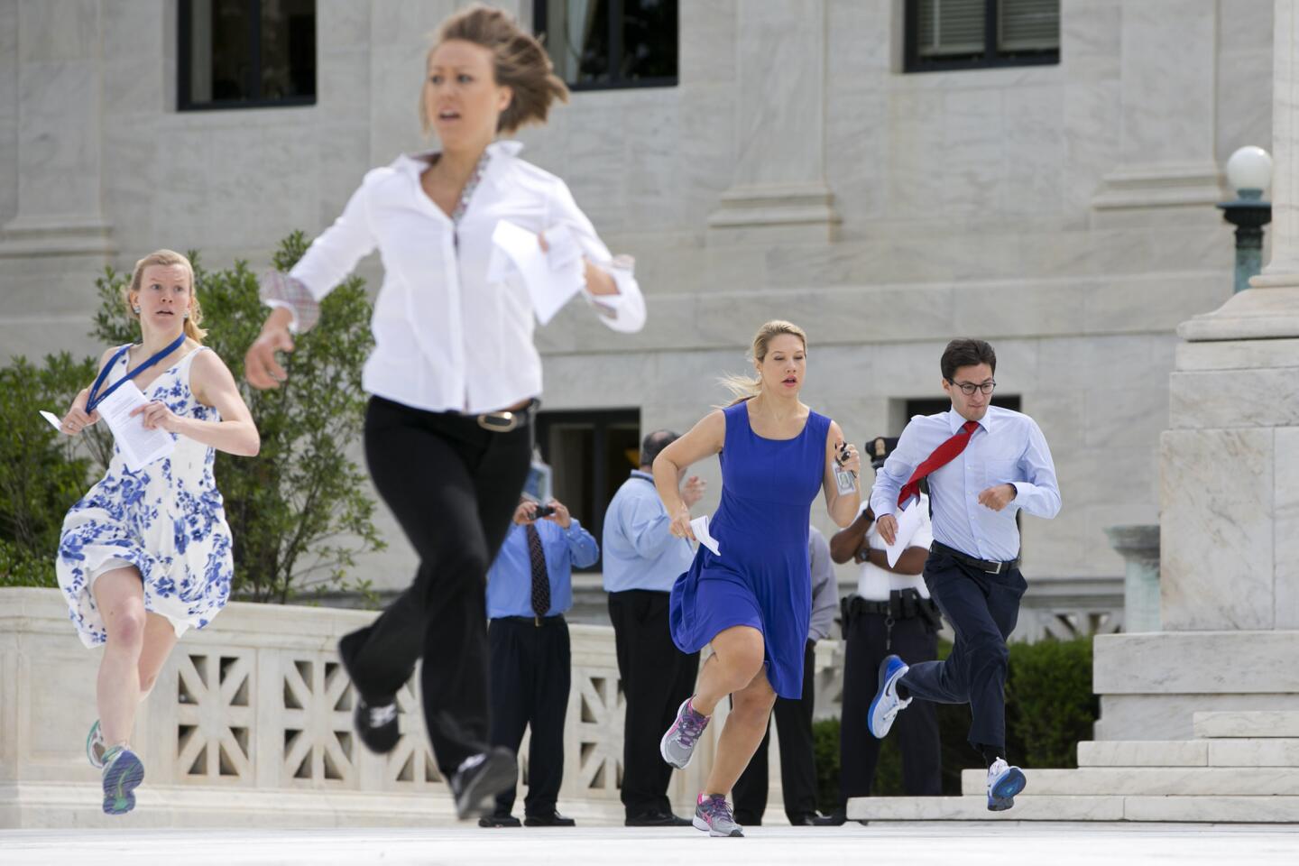 Interns run across the plaza of the Supreme Court in Washington, Thursday, June 25, 2015, to report the decided opinions to television stations, an event sometimes referred to as the "running of the interns." The Supreme Court on Thursday upheld the nationwide tax subsidies under President Barack Obama's health care overhaul, in a ruling that preserves health insurance for millions of Americans.