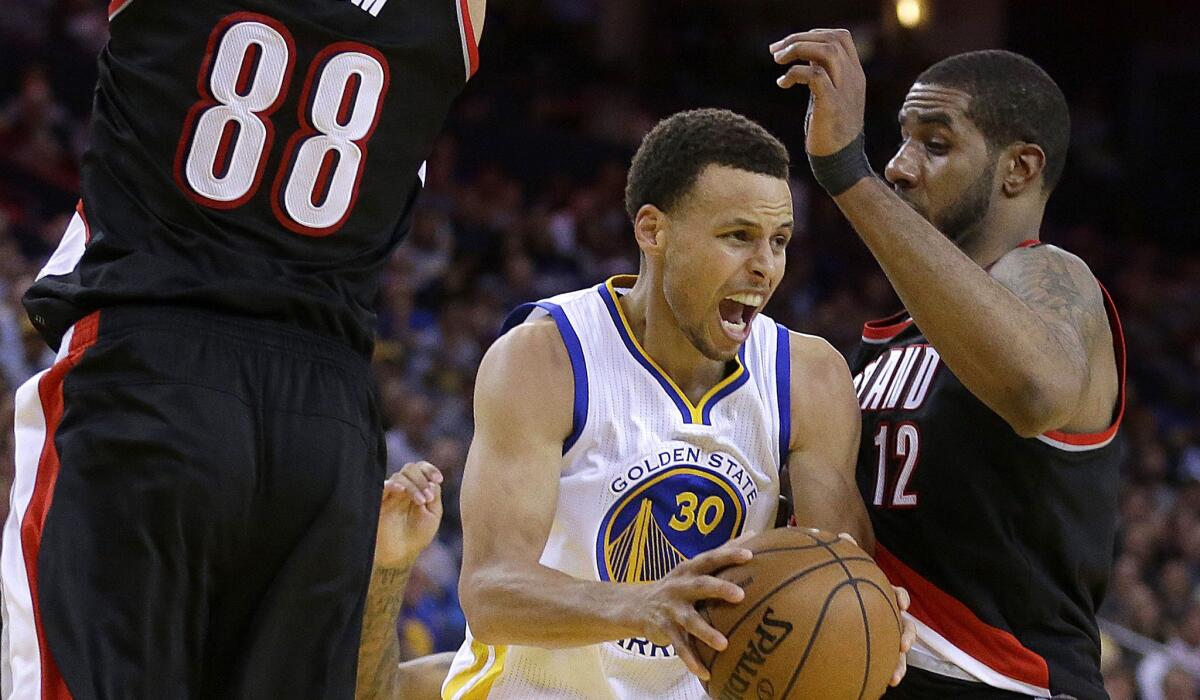 Warriors point guard Stephen Curry (30) looks to pass as he faces the double-team defense of Trail Blazers forwards Nicolas Batum (88) and LaMarcus Aldridge during the second half of an NBA basketball game Thursday, April 9, 2015, in Oakland, Calif. The Warriors won 116-105. (AP Photo/Ben Margot)