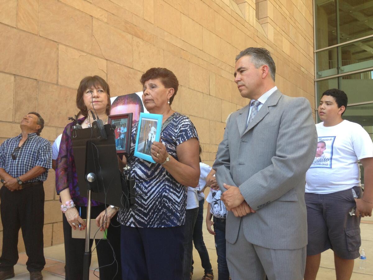 Jose Antonio Elena Rodriguez's grandmother, Taide Elena, displays pictures of the boy at a news conference in Tucson.